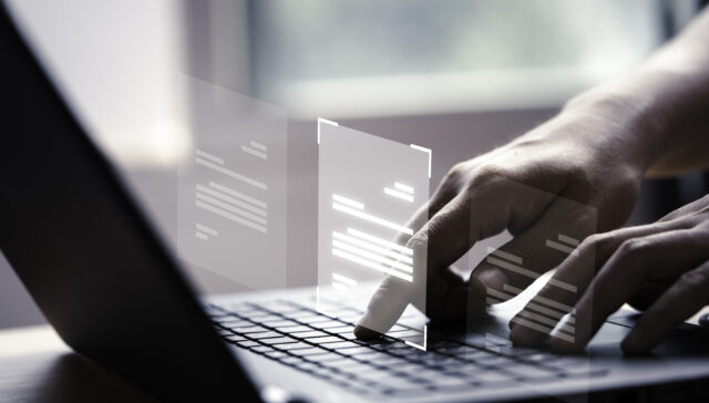 Hand using laptop computer with virtual screen and document for